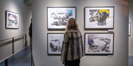 Eine Person betrachtet Bilder in einer Galerie