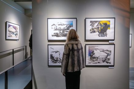 Eine Person betrachtet Bilder in einer Galerie