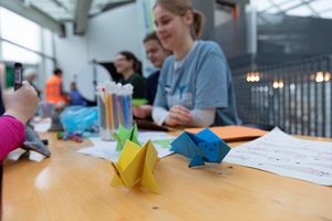 Kinder sitzen an einem Tisch und basteln