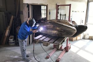 Der Bronzegiesser beim Schweißen an der Skulptur einer Lederschildkröte. 