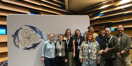 Personengruppe steht vor einem Aufsteller der European Cetacean Society 
