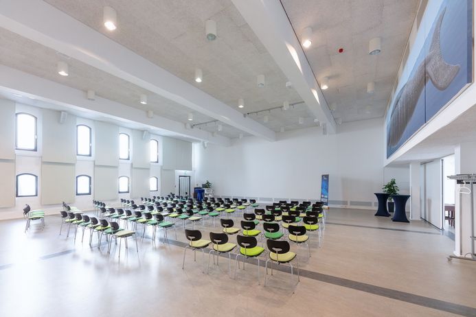 Eine weiße Halle mit Stuhlreihen