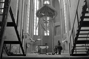 Schwarz-Weiß-Aufnahme eines hängenden Walskeletts in einer Kirchenhalle