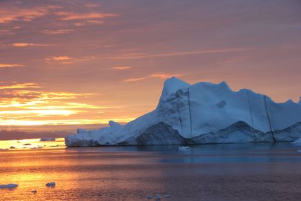 Blick auf einen Eisberg im Meer mit orange eingefärbtem Himmel. (Foto: Prof. Dr. Oliver Zielinski)