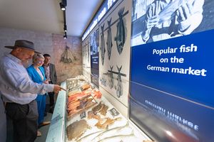 Menschen an einem Modell einer Fischtheke
