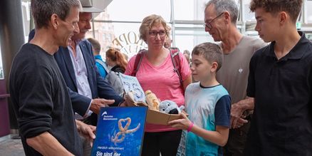 Eine Familie bekommt eine Urkunde überreicht