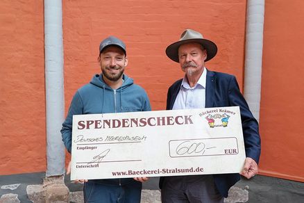 Bäcker Martin Krämer überreicht Andreas Tanschus einen Spendenscheck. (Foto: Anke Neumeister/Deutsches Meeresmuseum)