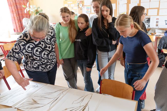 Gesprächssituation zwischen Lehrern und Schülern in einem Klassenzimmer