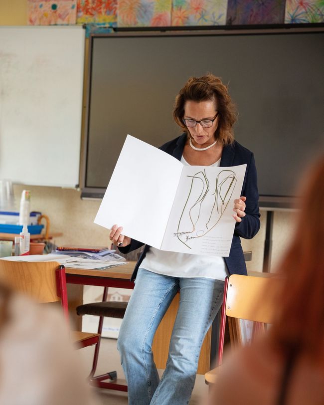 Eine Frau hält eine Mappe mit aufgeklebtem Seegras in den Händen