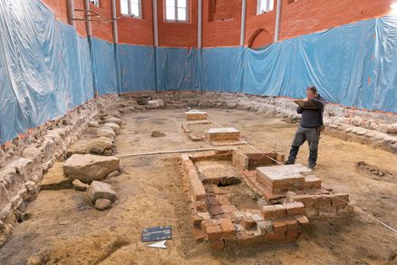 Mann steht vor Ausgrabungen in einer historischen Kirche