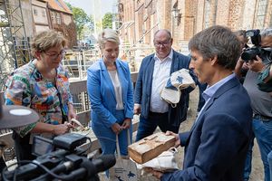 Burkard Baschek überreicht ein Backsteinbrot mit Seestern-Motiv, das als gemeinsames Spendenprojekt in Kooperation mit der Stralsunder Bäckerei Krämer entstand.  (Foto: Anke Neumeister/Deutsches Meeresmuseum)