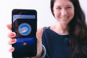 Eine Frau hält ein Smartphone mit der "Frag Walfred!" App in Richtung Kamera.