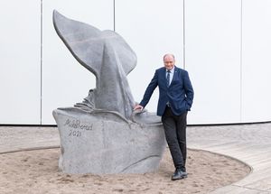 Ein Mann steht neben einer steinernen Walfluke