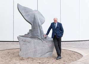 Ein Mann steht neben einer steinernen Walfluke