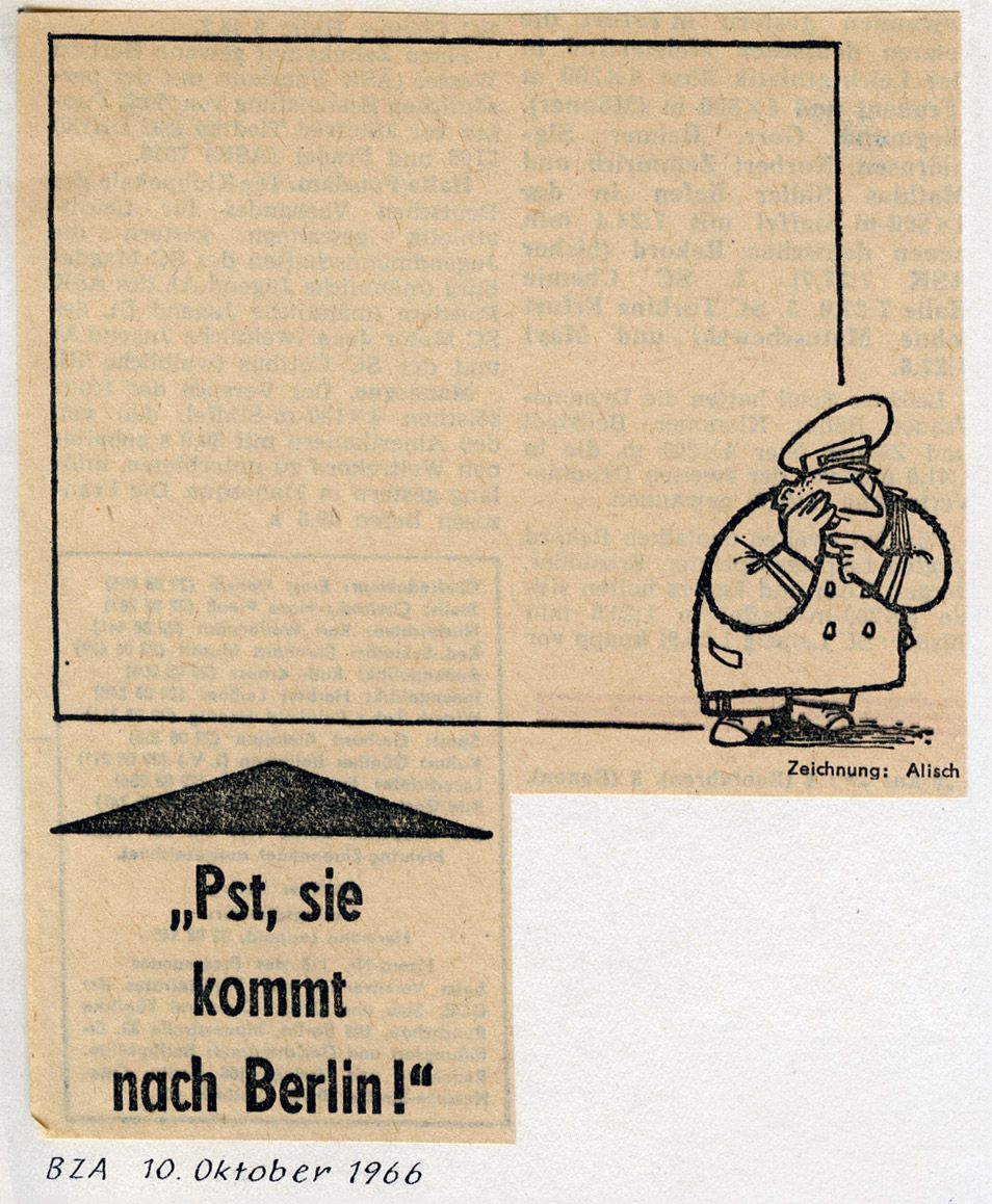 Karikatur zeigt einen Mann neben einem Viereck, darunter der Satz "Pst, sie kommt nach Berlin"
