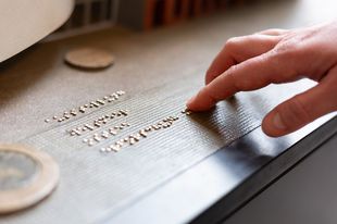 Eine Hand liest Brailleschrift