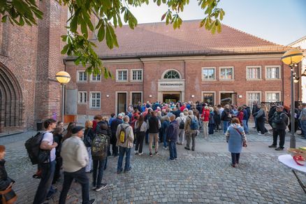 Menschen vor einem Backsteingebäude