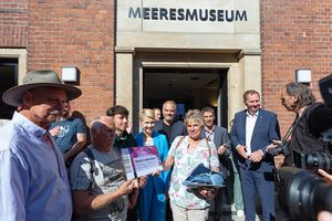 Menschen vor Gebäude mit Schriftzug „MEERESMUSEUM“