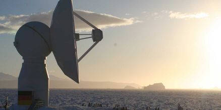 Empfangsstation in einer Schneelandschaft mit Sonnenaufgang.