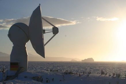 Empfangsstation in einer Schneelandschaft mit Sonnenaufgang.
