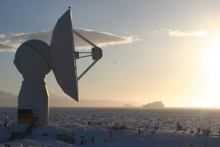 Empfangsstation in einer Schneelandschaft mit Sonnenaufgang.