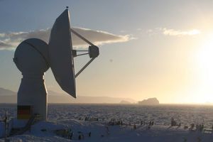 Empfangsstation in einer Schneelandschaft mit Sonnenaufgang.