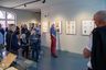 Besuchende betrachten Bilder in einer Galerie
